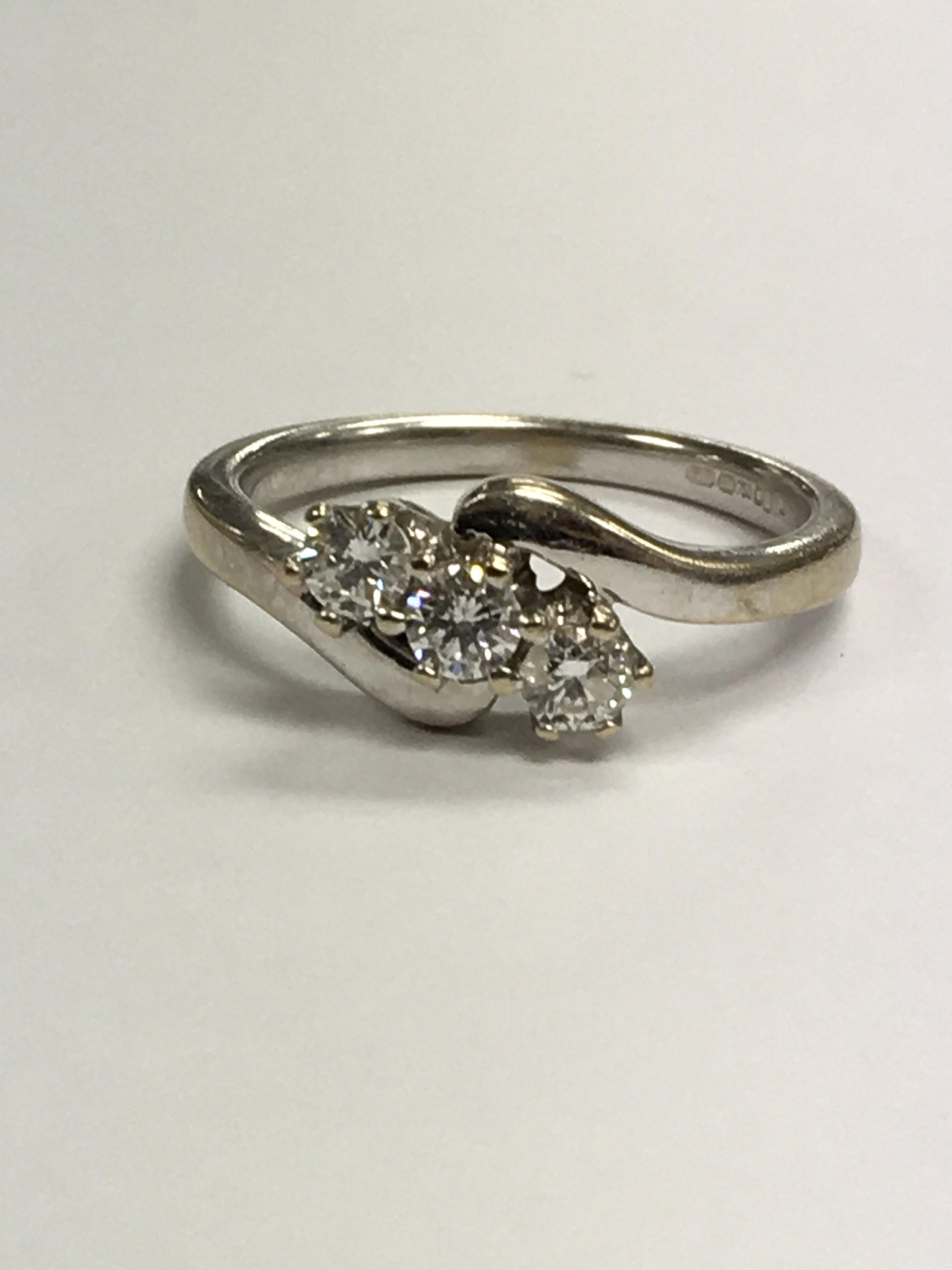 An 18 ct white gold diamond ring set with three br