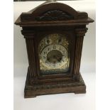 An oak cased chiming mantle clock with brass face