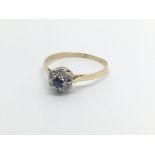 An 18carat gold ring set with a sapphire and a cluster of small diamonds ring size O-P.
