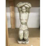 A stone garden ornament of a nude female figure in