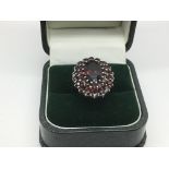 A silver garnet cluster ring, approx size P-Q.