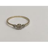 A small unmarked gold ring with floral design inse