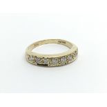 An 18carat gold ring set with a row of seven diamo