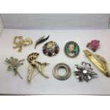 Ten costume brooches including a bow set with clea