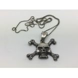 A sterling silver skull and crossbones pendant on