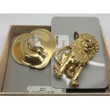 Two gold tone cabochon brooches, one in the form of a frog, the other as a lion.