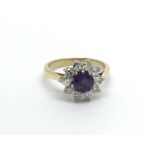 An 18carat gold ring set with amethyst flanked by