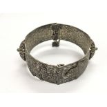 A silver bangle decorated with Egyptian symbols an