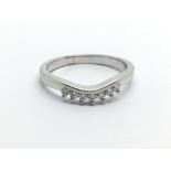 An unmarked white gold seven stone diamond ring, a