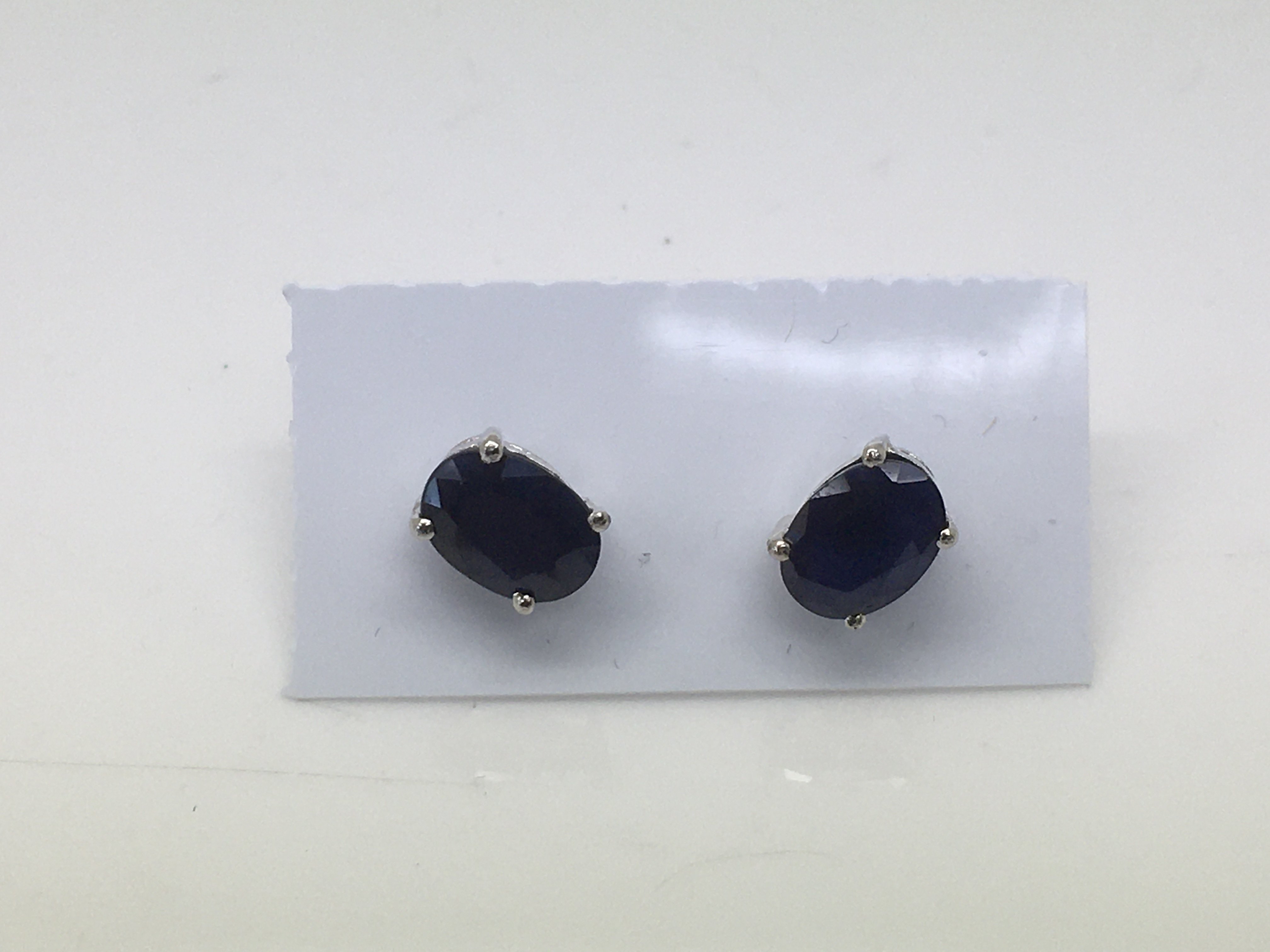 A pair of sapphire ear studs set in silver.