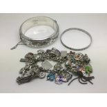 Two silver bangles and a silver charm bracelet (3)