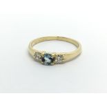 An 18ct gold ring set with a central topaz and two