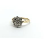 A vintage gold diamond cluster ring in the form of a flowerhead, approx 2.7g and approx size J.