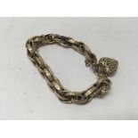 A fancy 9ct gold link bracelet with heart locket 1