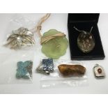 A collection of pendants and brooches.