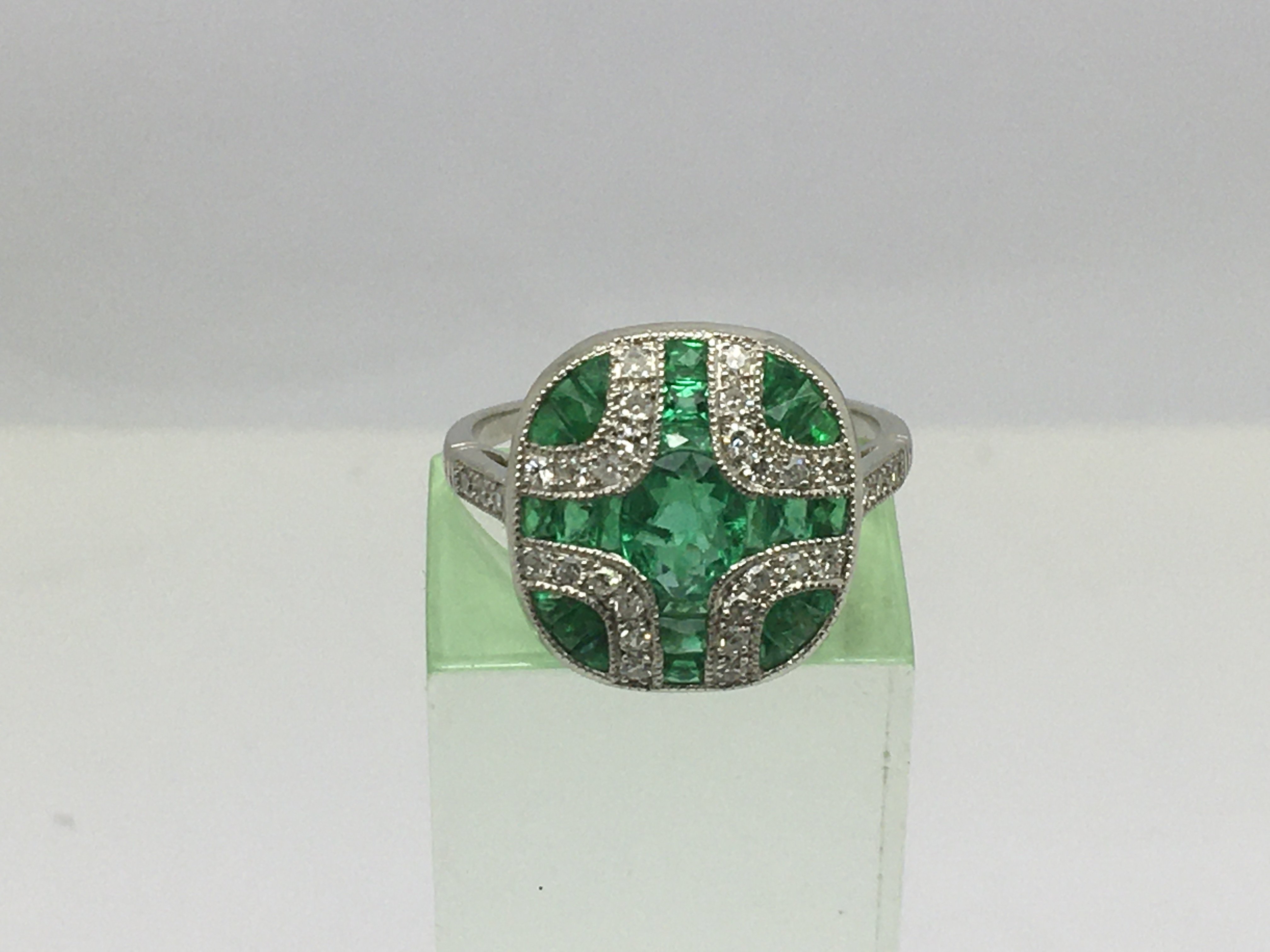 An Art Deco style platinum ring set with emeralds