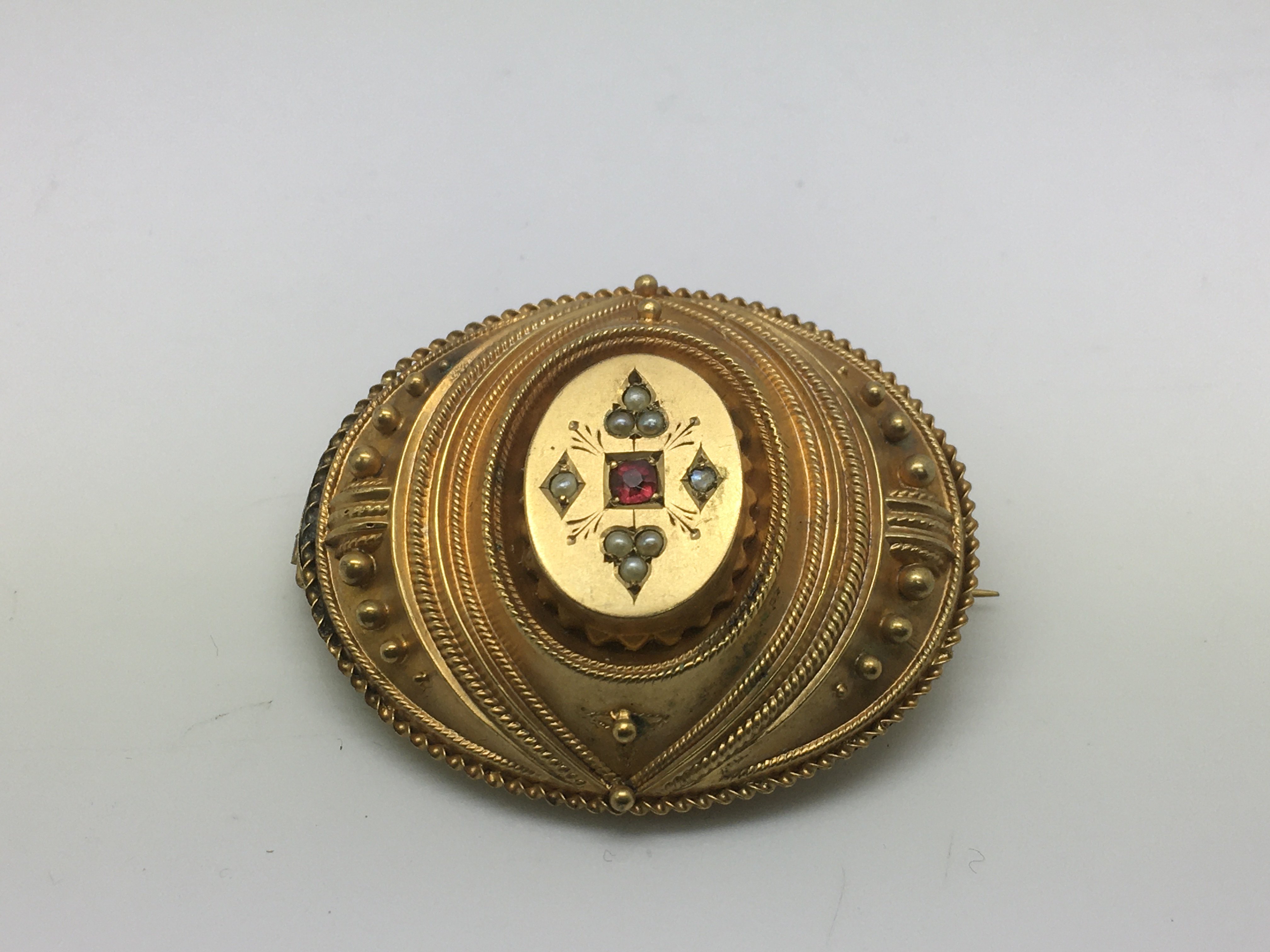 A yellow metal mourning brooch set with seed pearl
