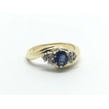 An 18carat gold ring set with a blue sapphire flanked by diamonds ring size G-H