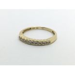 An 18ct gold half eternity diamond ring set with t