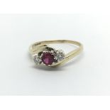 A 9ct gold ring set with a central red stone and two diamonds, aporox .20ct, approx 2.9g and