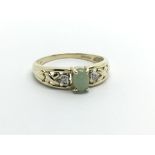 A 9ct gold ring set with a central jade stone and small diamonds to either side, approx 2g and