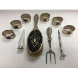 A collection of silver and white metal items compr
