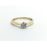 An unmarked gold ring set with seven diamonds in the form of a flowerhead, approx 1.6g and approx