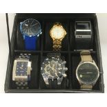 A watch display case containing six watches includ