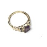An 18ct gold ring set with a central amethyst and