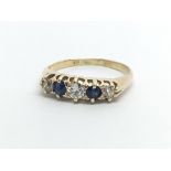 A vintage 18ct gold ring set with three diamonds and two sapphires, approx 2g and approx size I-J.