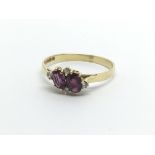An 18ct gold ring set with two armadine garnets and four small diamonds, approx 2g and approx size
