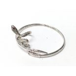 A sterling silver snake bangle with stone set eyes