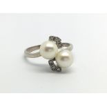 An 18ct white gold diamond and pearl ring. (S), 4.2g.