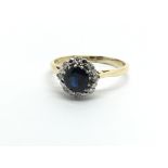 An 18ct gold ring set with a central sapphire and surrounded by diamonds, approx 2.8g and approx