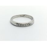 An 18ct white gold seven stone diamond ring, approx .12ct and approx size N-O.