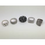 Five silver rings of various designs.