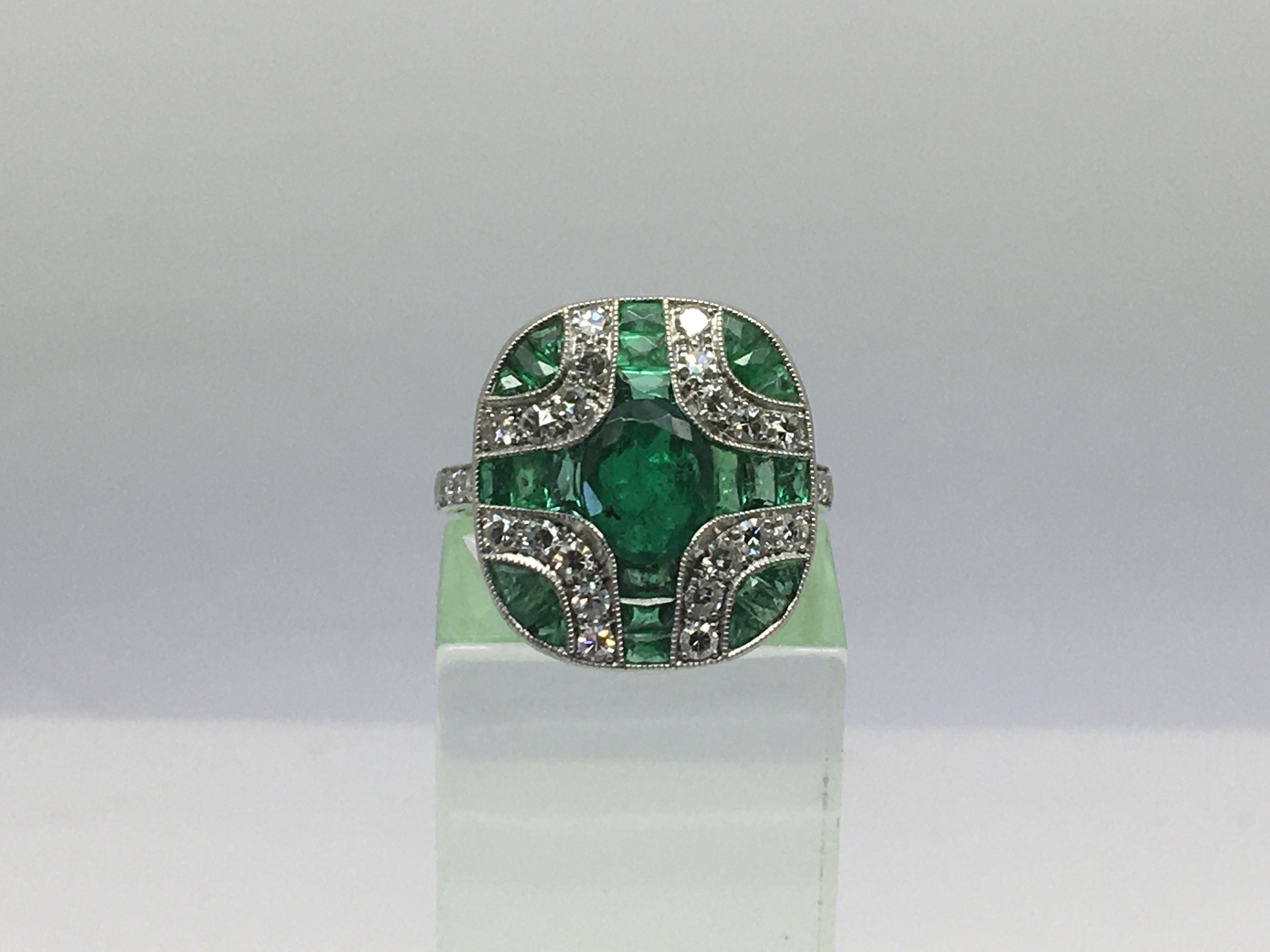 An Art Deco style platinum ring set with emeralds