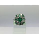 An Art Deco style platinum ring set with emeralds