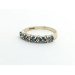 A gold ring set with alternating diamonds and topaz, approx 1.6g and approx size K-L.