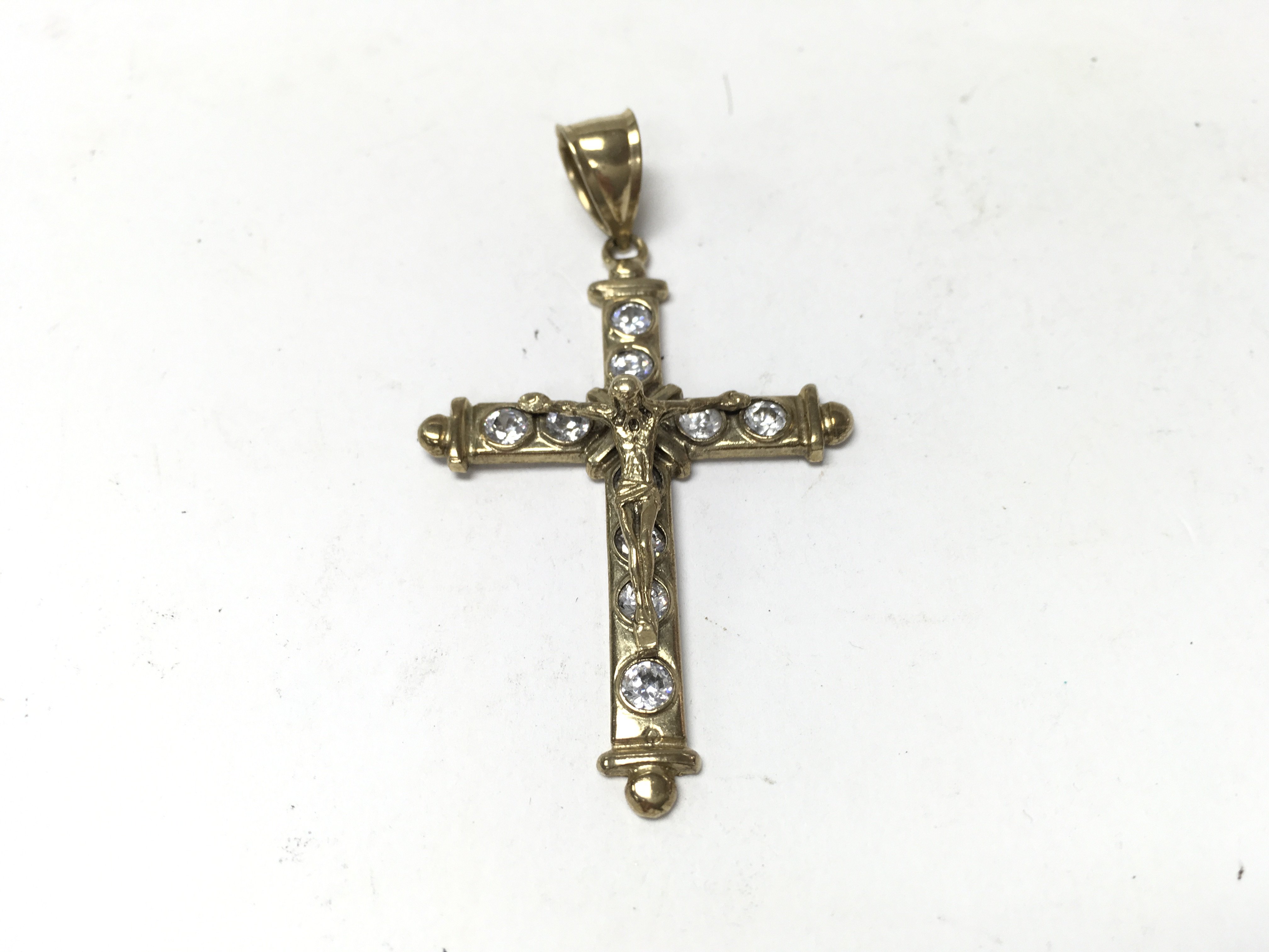 A 9ct gold crucifix pendant set with white stones.