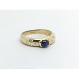 An 18ct gold ring set with a central cabochon sapphire and eight small diamonds, approx 3g and