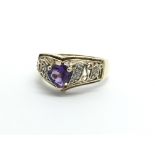 An unmarked gold ring set with a central amethyst and diamonds either side, approx 3.1g and approx