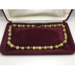 A multi coloured jade necklace with a 9ct gold cla