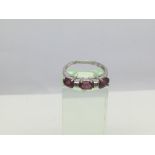 A 9ct white gold three stone ring, possibly garnet