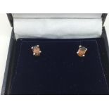 A boxed pair of brown tourmaline ear studs, set in