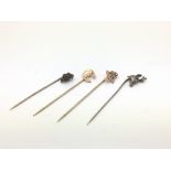 Four antique stick pins comprising a stag's head,