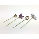 Four stick pins including a heart shaped citrine,