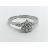 An unmarked white gold ring set with diamonds in the form of a flowerhead, approx .33ct, approx 2g