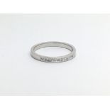 An unmarked white gold half eternity ring set with princess cut diamonds, approx 2.2g and approx