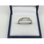 A 9ct white gold ring set with five clear stones,